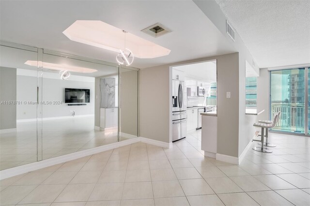 interior space featuring light tile patterned floors and a textured ceiling