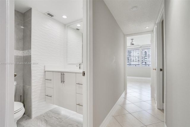 bathroom with vanity, a textured ceiling, and toilet