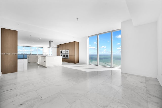 unfurnished living room with a water view and floor to ceiling windows