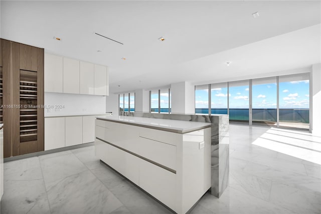 kitchen featuring white cabinets, a center island, and floor to ceiling windows