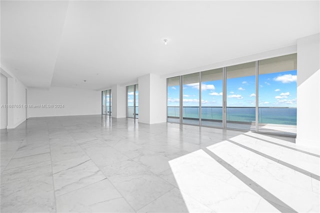 empty room featuring a wall of windows and a water view