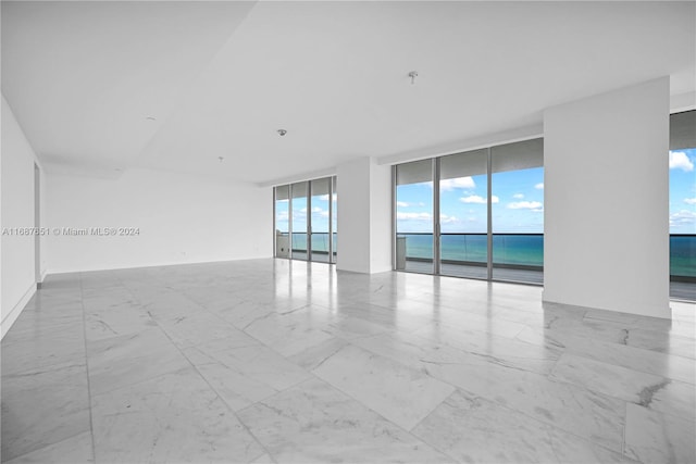 empty room with expansive windows and a water view