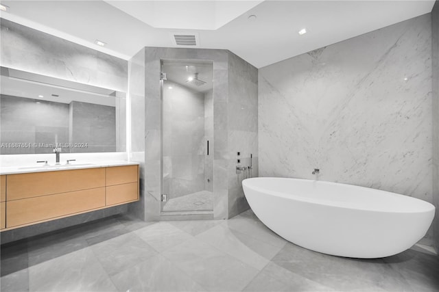 bathroom with vanity, plus walk in shower, and tile walls