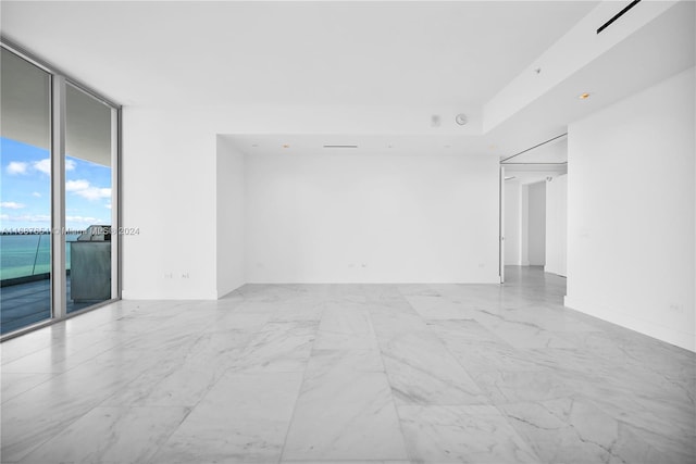 empty room with expansive windows and a water view