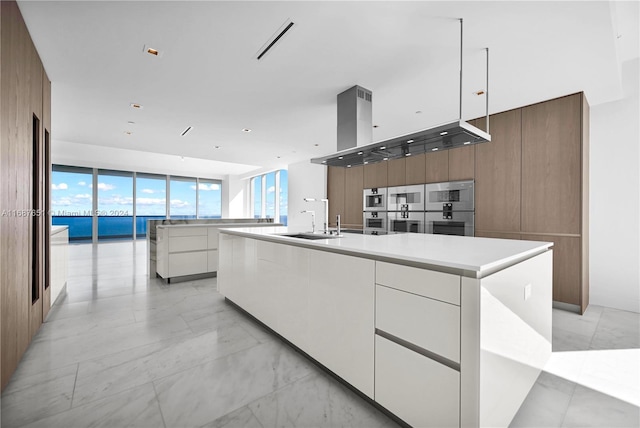 18501 Collins Ave Unit 4003/04, Sunny Isles Beach, FL 33160 - kitchen featuring modern cabinets, a sink, a large island with sink, white cabinets, and a wall of windows