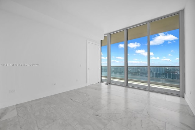 empty room with a water view and a wall of windows