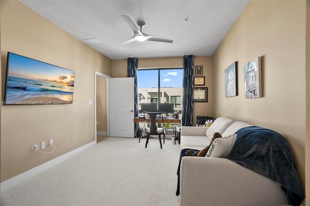 office featuring ceiling fan, a textured ceiling, and light colored carpet