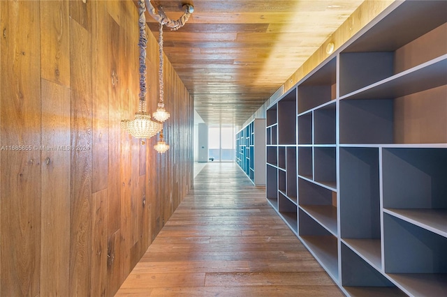 hallway with hardwood / wood-style flooring, wood ceiling, and wooden walls