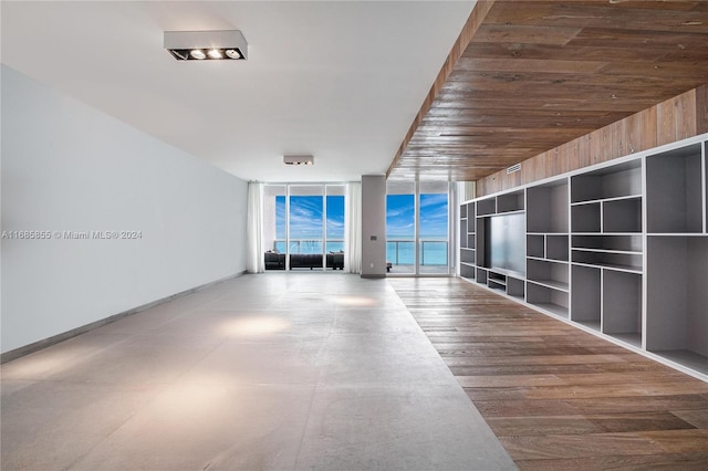 empty room with hardwood / wood-style flooring and a wall of windows