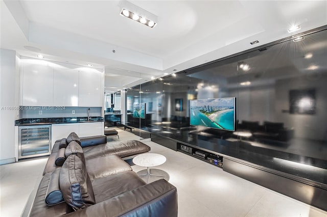 living room with a raised ceiling, sink, and beverage cooler