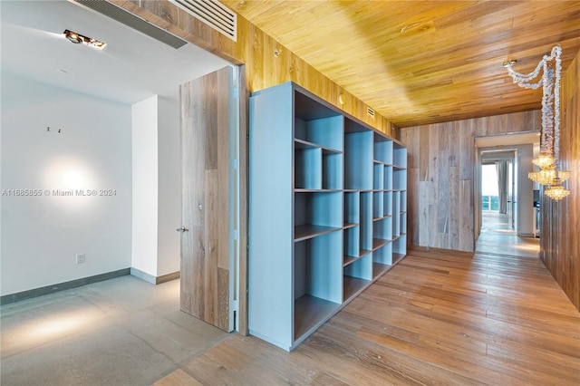 hall with wooden ceiling, hardwood / wood-style flooring, and wooden walls