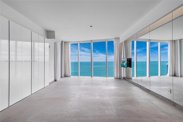 empty room with a water view and floor to ceiling windows