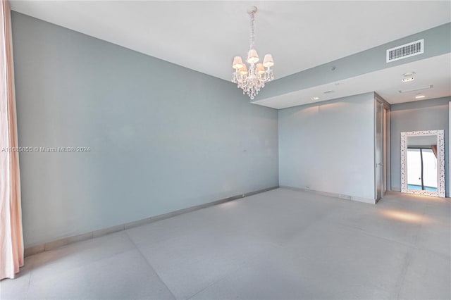 unfurnished room with a chandelier