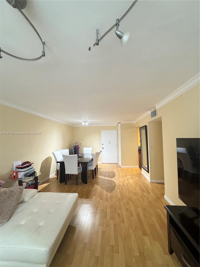 dining room featuring crown molding and light wood-type flooring