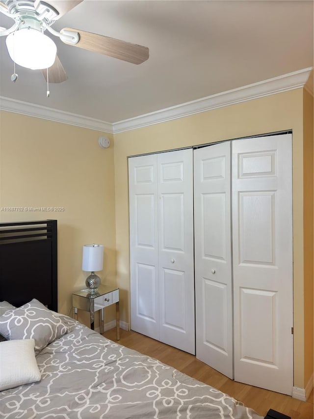 bedroom with crown molding, a closet, ceiling fan, and light hardwood / wood-style flooring