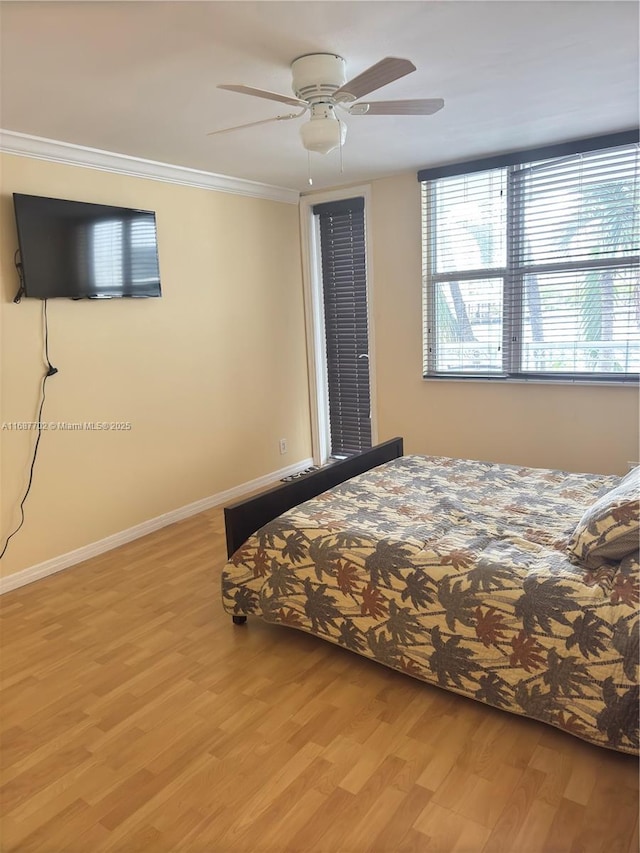 unfurnished bedroom with crown molding, ceiling fan, and light wood-type flooring