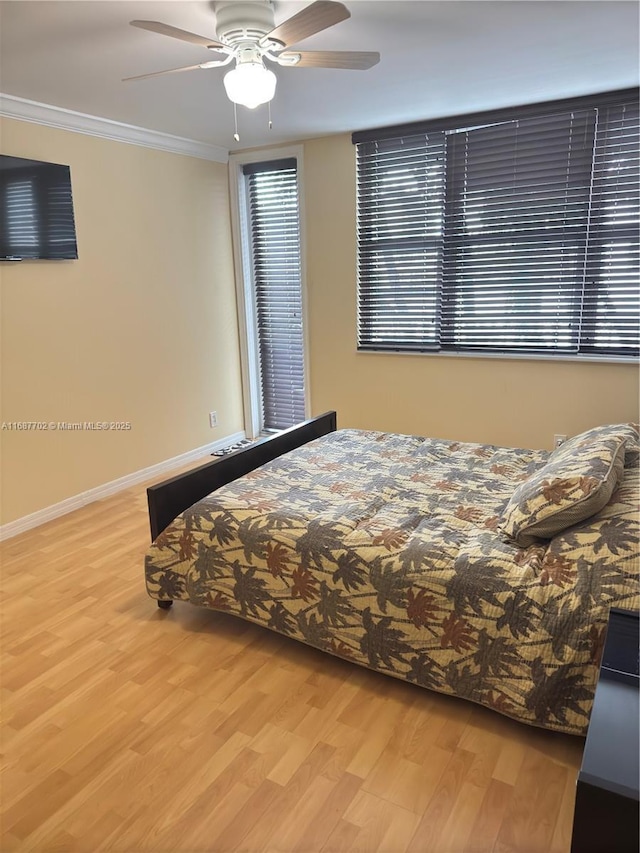 bedroom with ornamental molding, light hardwood / wood-style floors, and ceiling fan