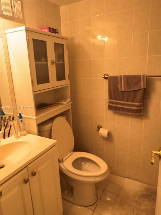 bathroom featuring vanity, tile walls, tile patterned floors, and toilet