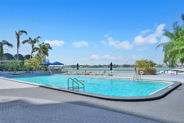 view of pool with a gazebo, a water view, and a patio