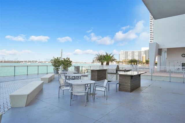 view of patio / terrace featuring area for grilling, a grill, and a water view