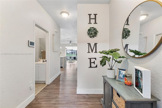 7859 Catalina Cir Unit 7859, Tamarac, FL 33321 - hall with a sink, dark wood-style flooring, a textured wall, and baseboards