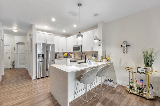 kitchen with white cabinetry, appliances with stainless steel finishes, light hardwood / wood-style flooring, and sink