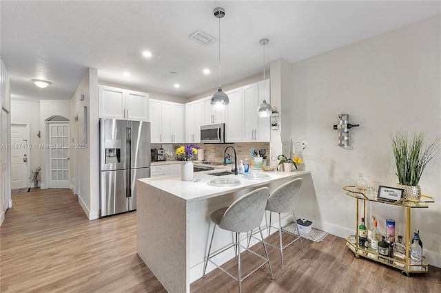 7859 Catalina Cir Unit 7859, Tamarac, FL 33321 - kitchen featuring a peninsula, a sink, stainless steel appliances, visible vents, and baseboards