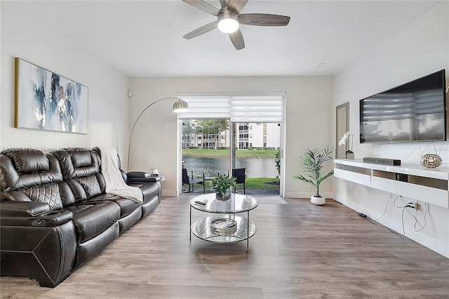 living room featuring wood-type flooring and ceiling fan