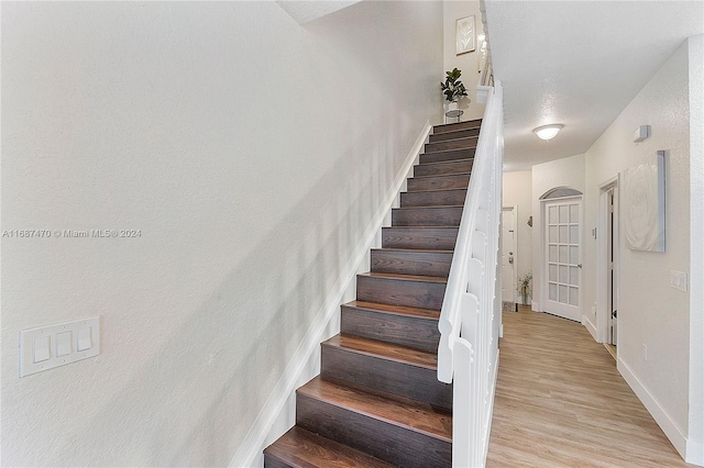 stairs featuring hardwood / wood-style flooring