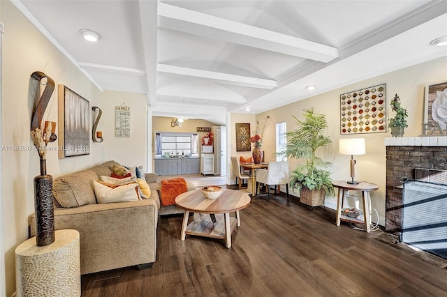 living room with dark wood-type flooring, beamed ceiling, and a brick fireplace