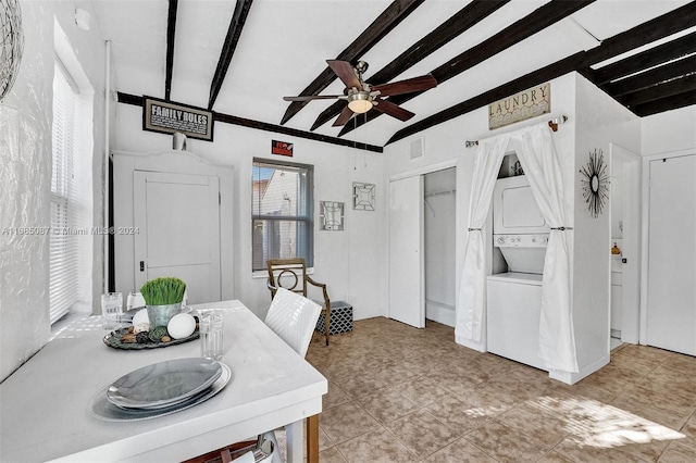 tiled dining room with ceiling fan, beam ceiling, and stacked washer / drying machine