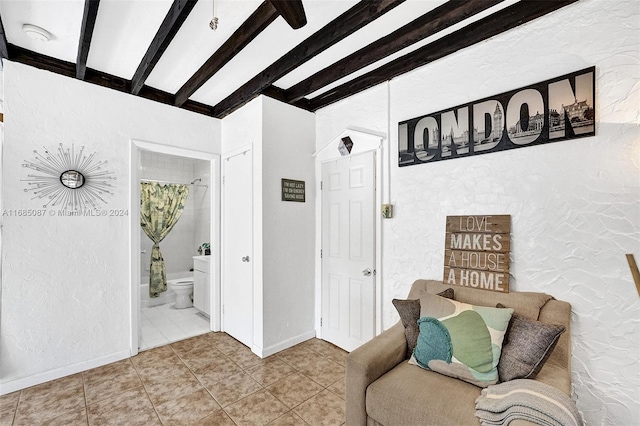 sitting room with tile patterned flooring and beam ceiling