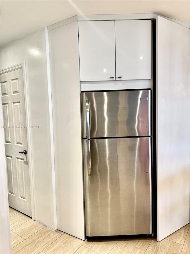 kitchen with stainless steel fridge and light hardwood / wood-style floors