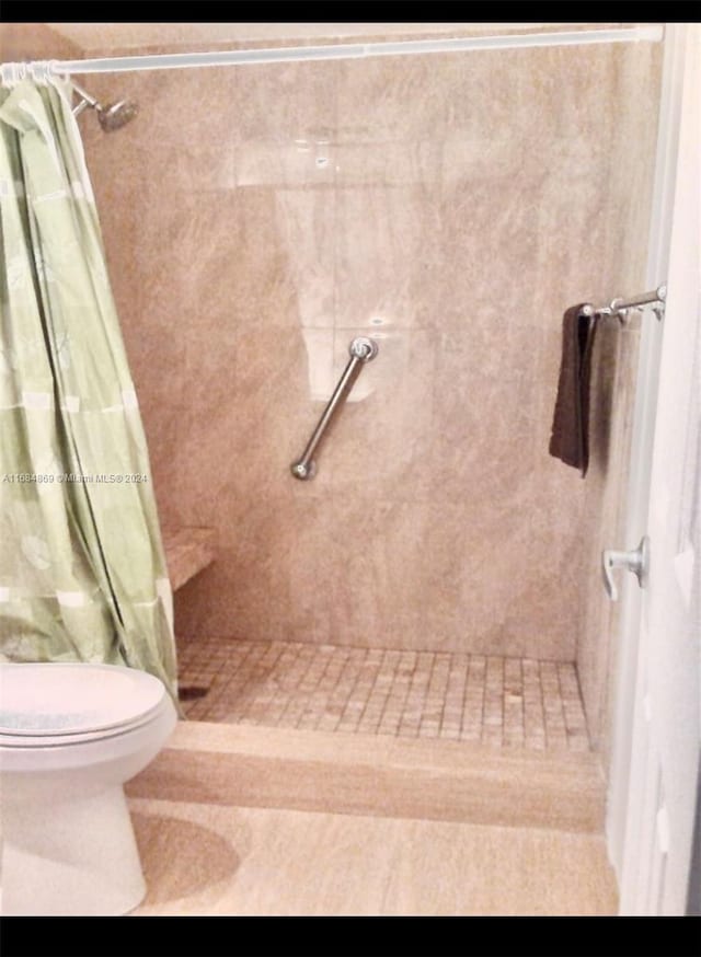 bathroom featuring curtained shower and toilet