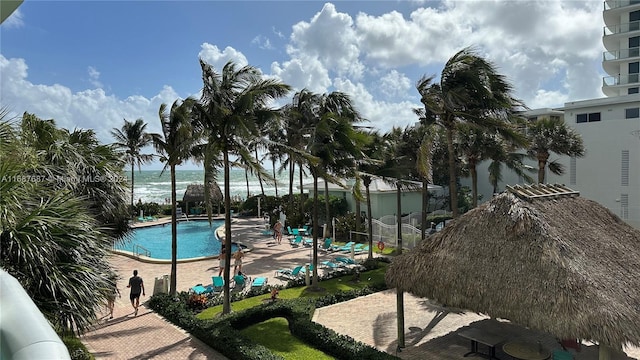 view of swimming pool with a water view and a patio