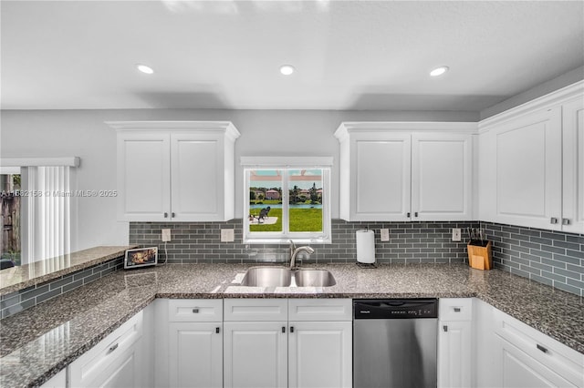 kitchen featuring tasteful backsplash, white cabinetry, dishwasher, sink, and dark stone counters