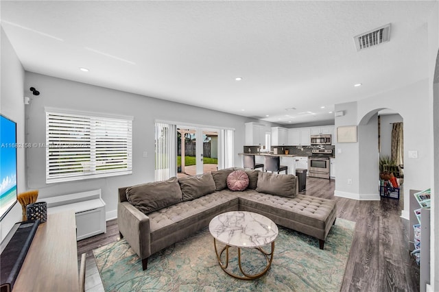 living room with french doors, hardwood / wood-style floors, and a textured ceiling