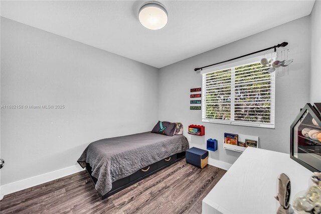 bedroom with dark hardwood / wood-style flooring