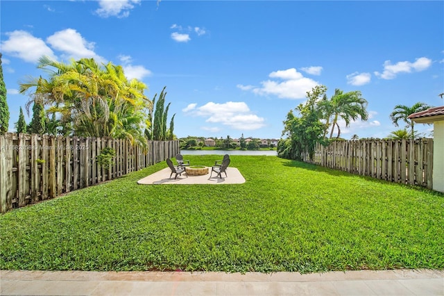 view of yard with a water view, an outdoor fire pit, and a patio