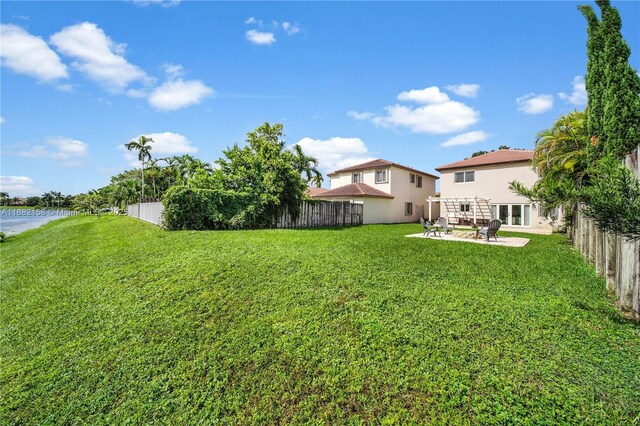 rear view of house featuring a yard, a pergola, and a patio