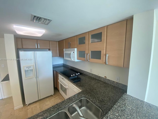 kitchen with white appliances and dark stone counters