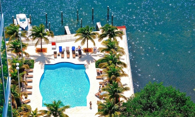 view of pool featuring a patio area and a water view