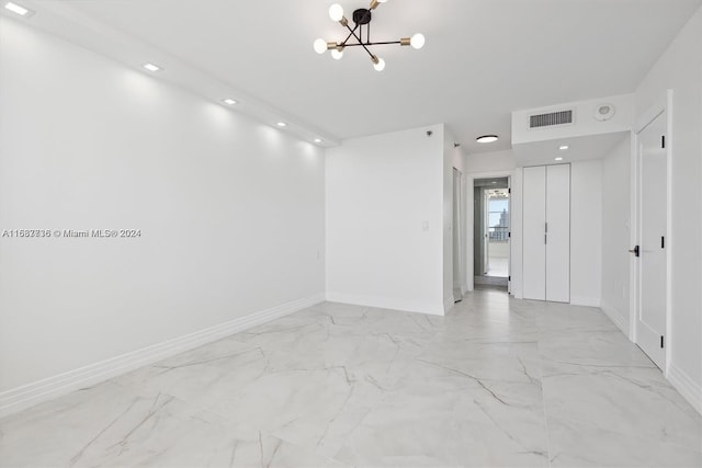 unfurnished room featuring an inviting chandelier