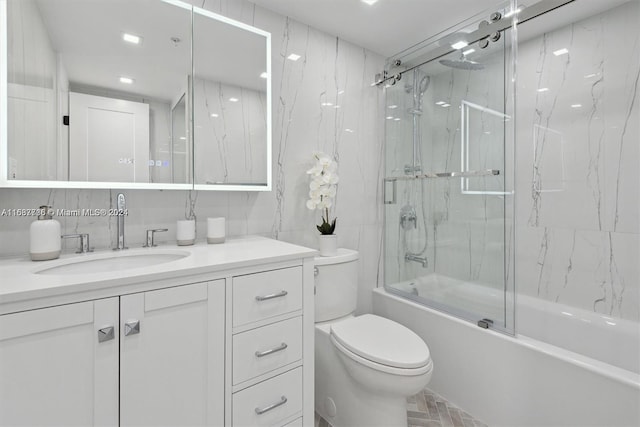 full bathroom featuring toilet, combined bath / shower with glass door, and vanity