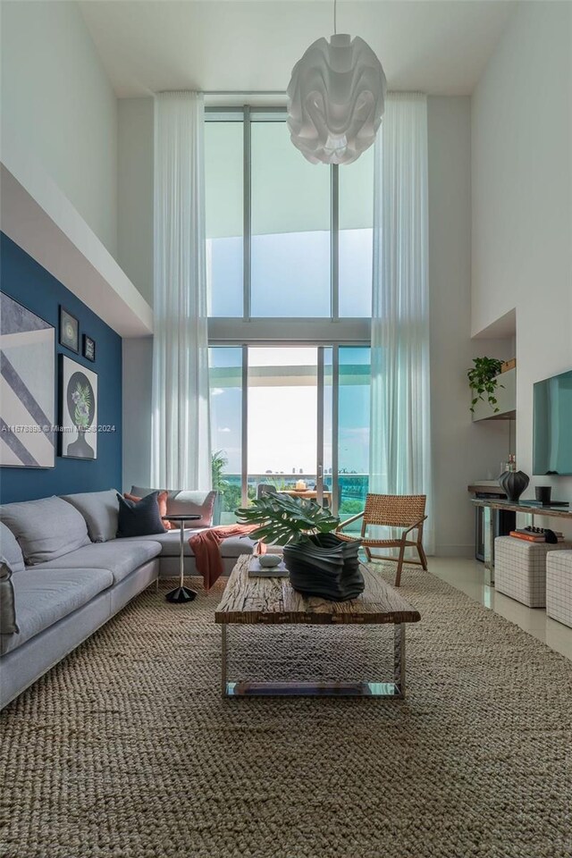 living room with a high ceiling and floor to ceiling windows