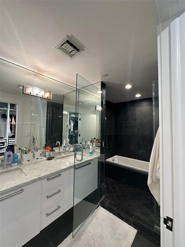 bathroom featuring vanity and independent shower and bath