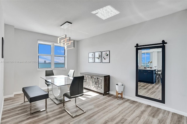 dining area featuring a textured ceiling, light hardwood / wood-style flooring, and a wealth of natural light