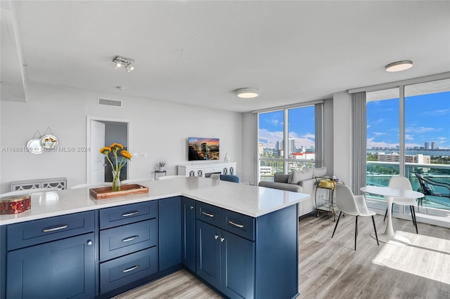 kitchen featuring expansive windows, light hardwood / wood-style flooring, and kitchen peninsula