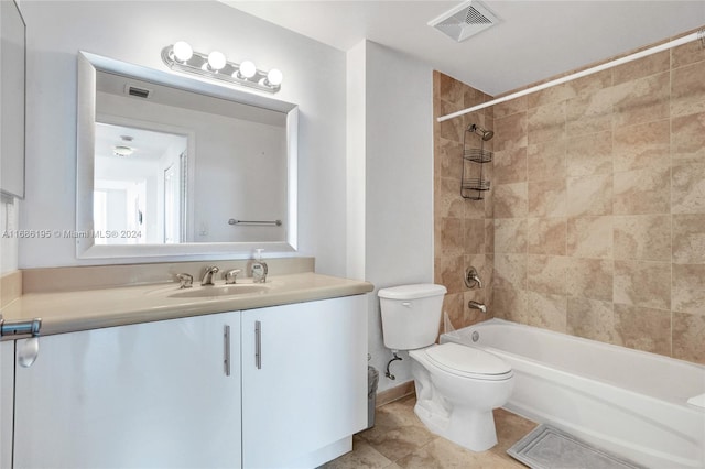 full bathroom featuring toilet, tiled shower / bath, vanity, and tile patterned flooring