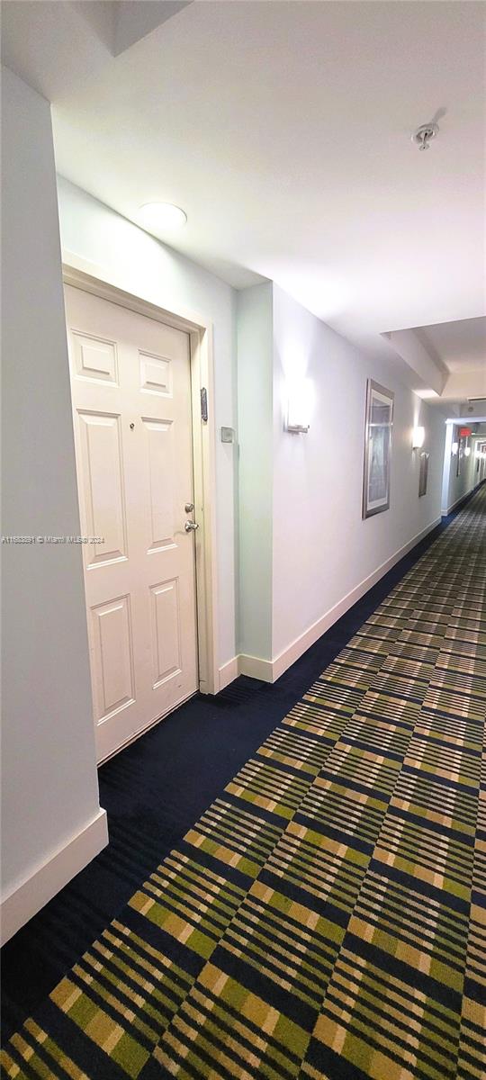 hallway with dark colored carpet